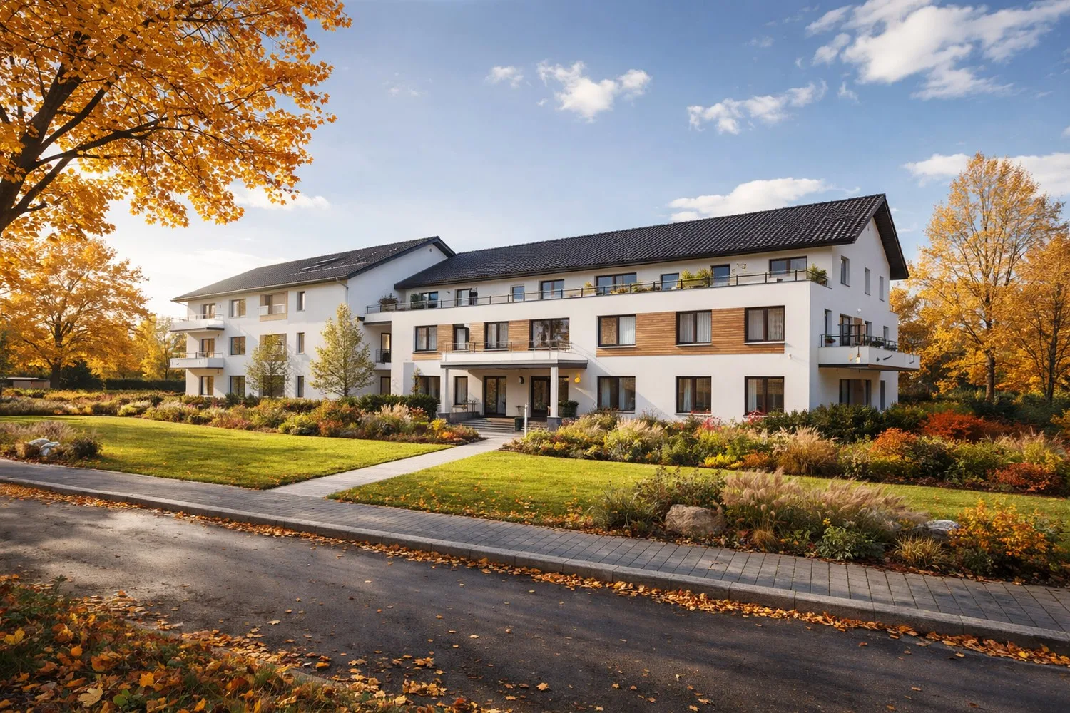 Ansicht des VIDA PARK Ballrechten-Dottingen mit Hauptzugang und Gartenanlage im Herbst